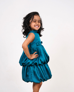 Faye Peacock Blue Tiered Dress with a halter neck, balloon hemline, and two bows on the waist.
