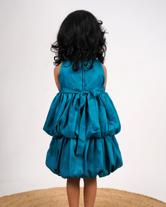 Faye Peacock Blue Tiered Dress with a halter neck, balloon hemline, and two bows on the waist.
