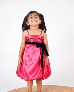 Faye Fuchsia Strappy Dress with a velvet sash and balloon hemline.
