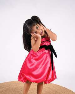 Faye Fuchsia Strappy Dress with a velvet sash and balloon hemline.
