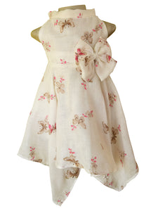 A Cream and pink butterfly print cowl neck dress featuring an empire waistline and an oversized
bow on the side. The handkerchief skirt flows smoothly on either side.