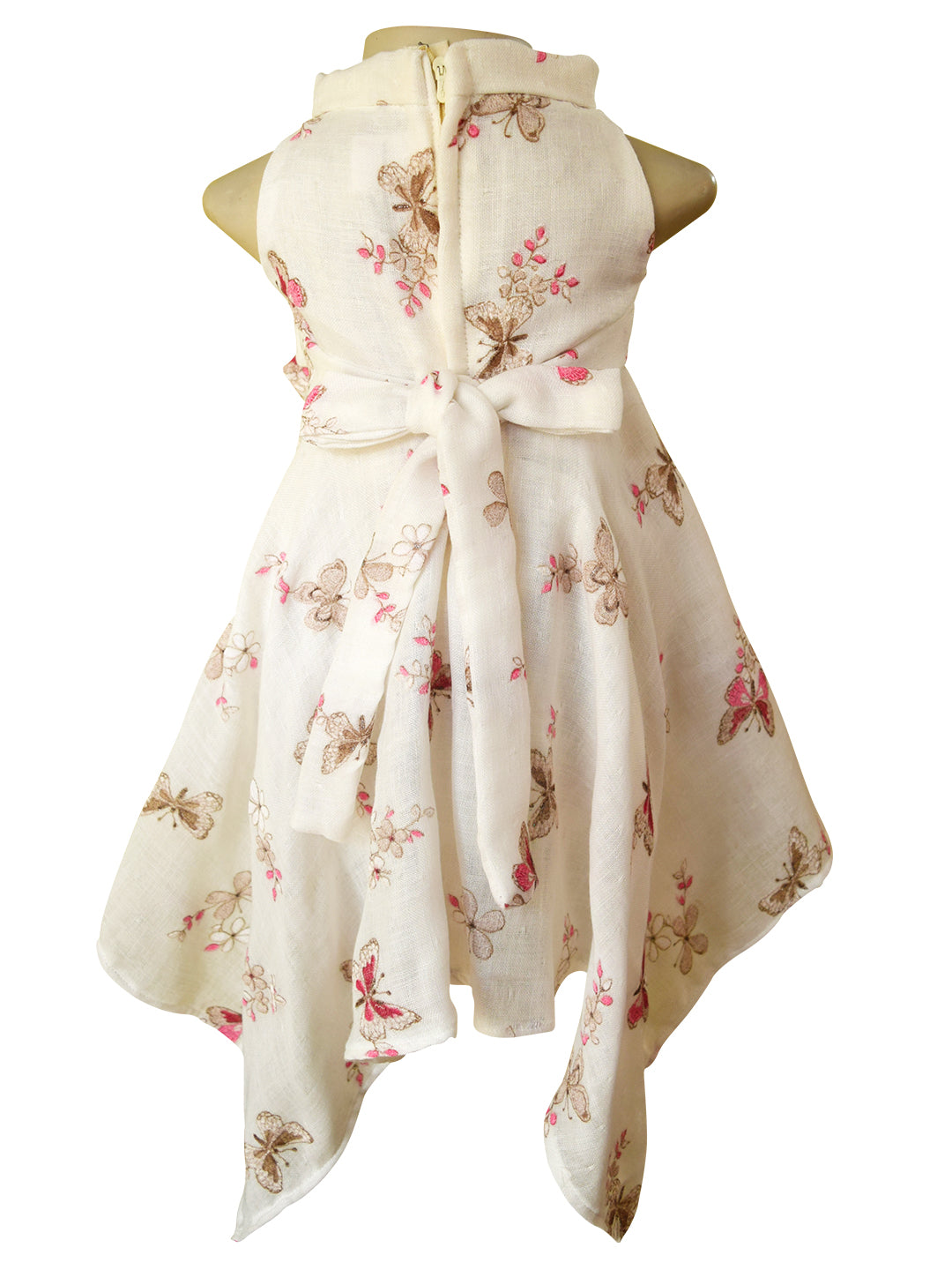 A sleeveless handkerchief dress displayed on a mannequin torso, featuring a cream base with a  butterfly and pink floral print pattern, shown from the back.