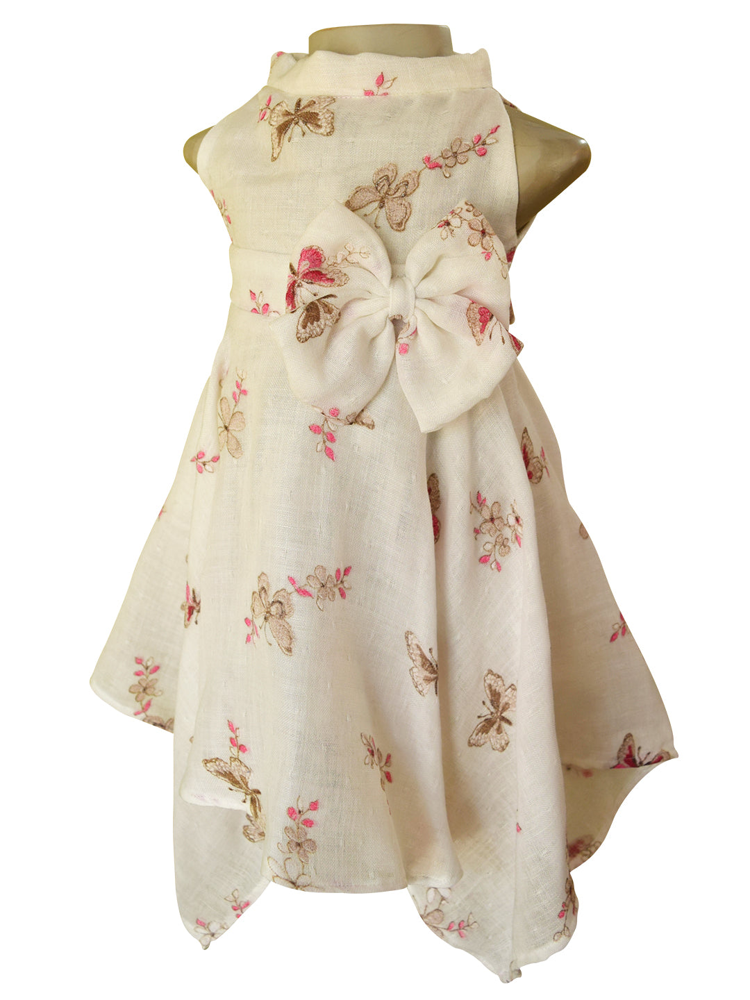 A sleeveless high-low dress displayed on a mannequin torso against a white background. The dress is cream-colored with a large matching fabric bow at the waist and features a scattered butterfly and floral print in brown and pink.