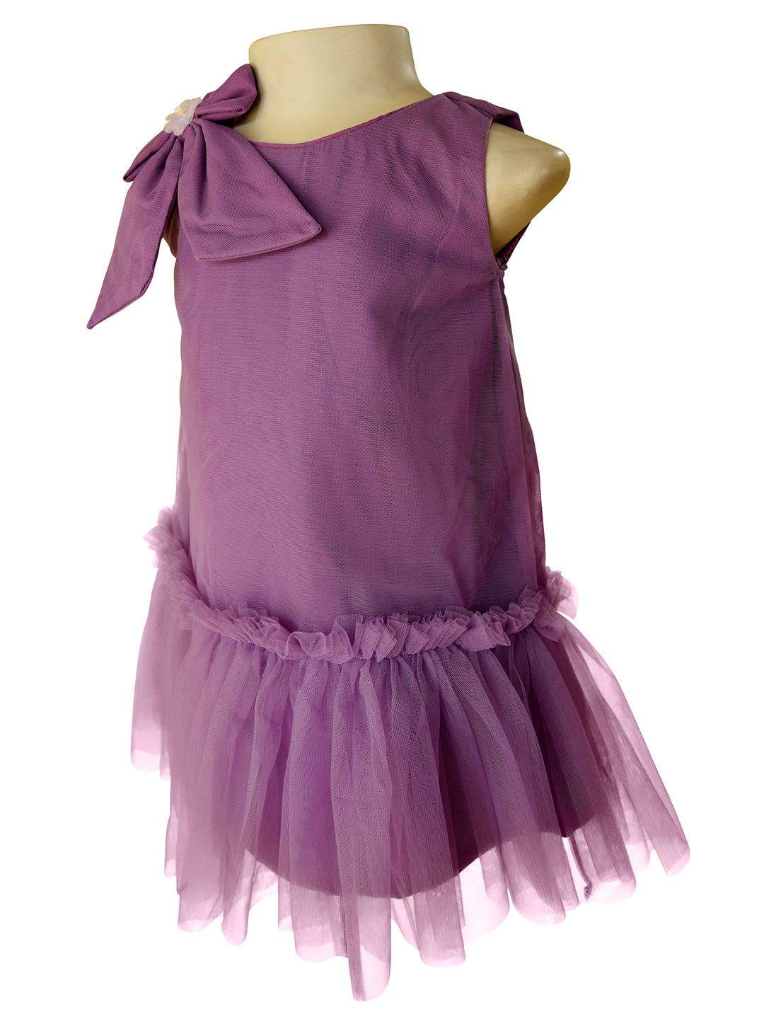A sleeveless toddler girl's dress in dusty purple, displayed on a mannequin. The dress features a large bow detail on the shoulder, a ruffled tulle hem, and a tiered tulle skirt.