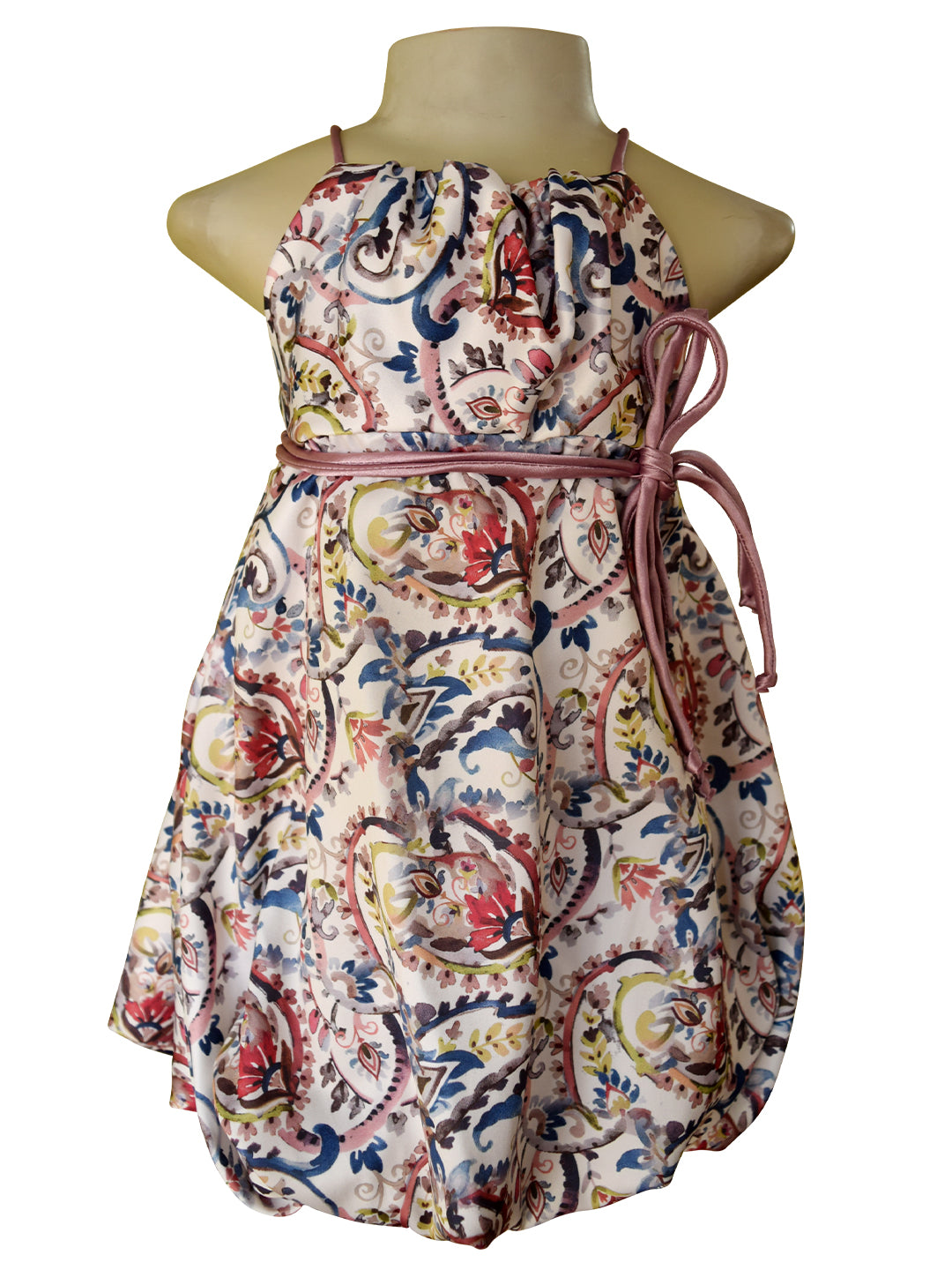 A sleeveless halter dress displayed on a mannequin torso against a plain white background. The dress has an allover paisley-style print with cream, red, blue, green, and yellow tones, and is cinched at the waist with a mauve tie belt.