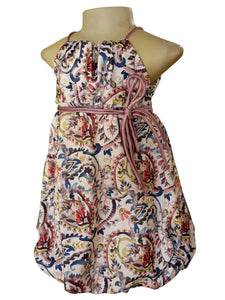 A sleeveless halter dress displayed on a mannequin torso against a plain white background. The dress has an allover paisley-style print with a cream base and multicolored motifs in blue, red, green, and yellow, accented by a mauve pink tie belt at the waist.