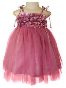 A tutu style girls' party dress in mauve colour. This dress features  bodice with 3D fabric flowers, thin shoulder ties, and a voluminous tulle skirt.