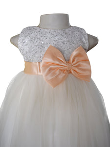 A dress in Silver Sequin bodice and Ivory net skirt with Peach colour sash & bow at the waist
