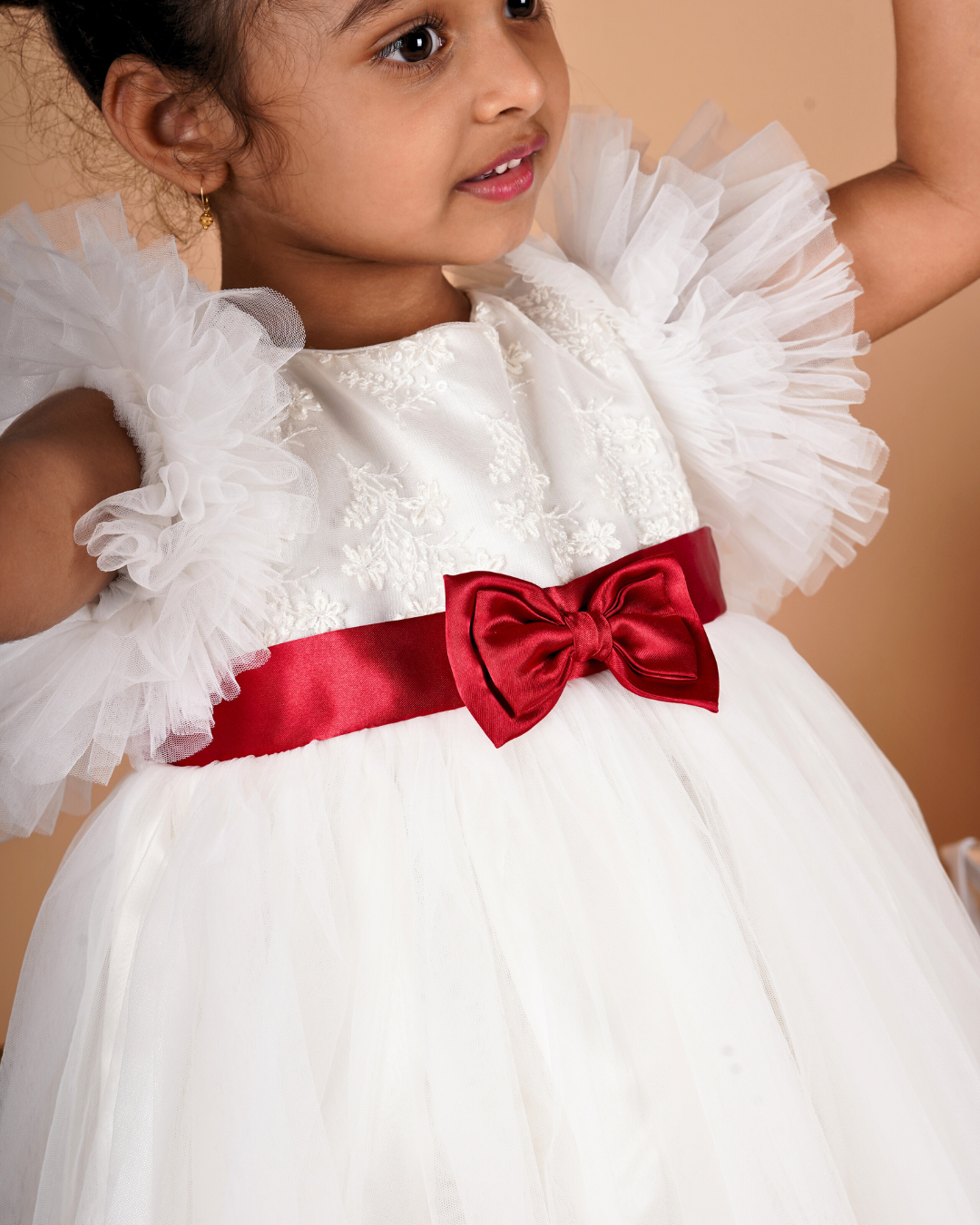 Young girl wearing the Faye Ivory Ruffle Sleeve Dress 