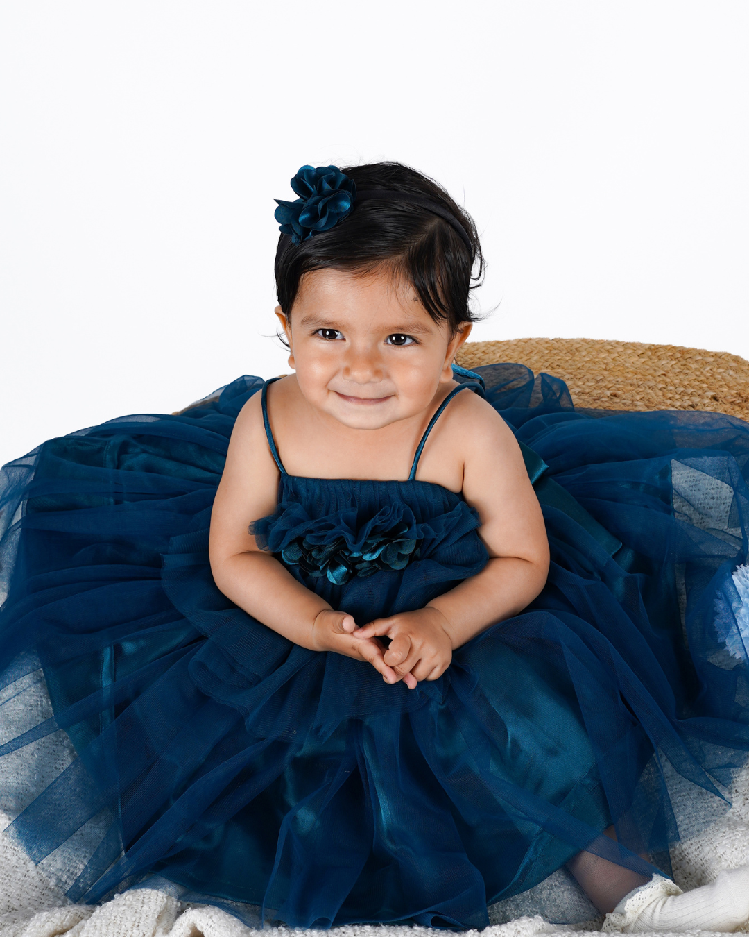 Toddler wearing the Faye Teal Green Asymmetric Dress with a floral headband