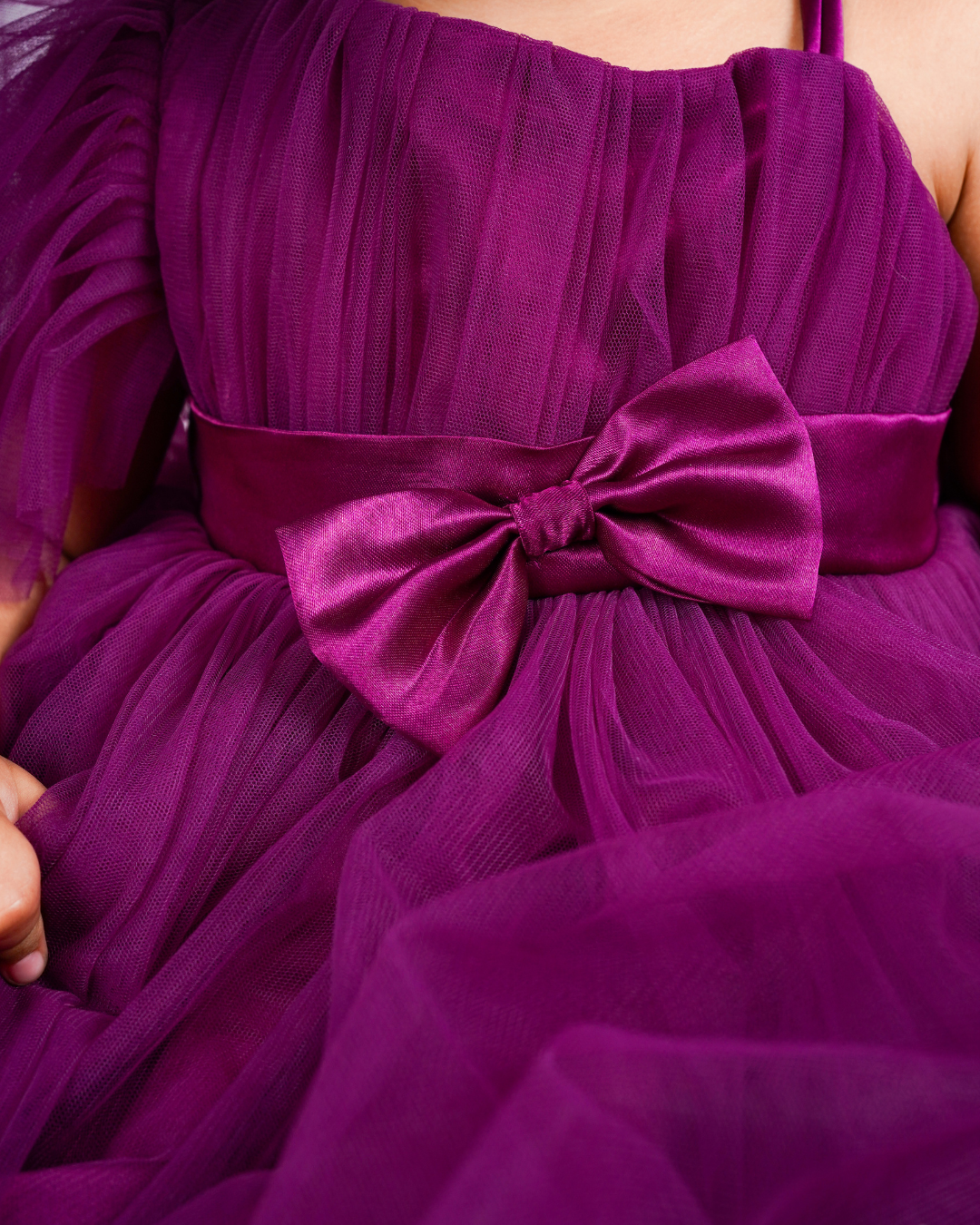 Close-up of the Faye Wine One Shoulder Dress with a large bow detail.